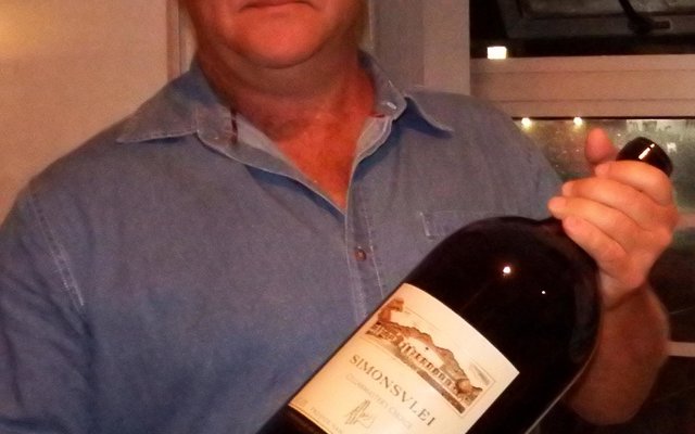 Leon Engkle (links) ontvang die bottel wyn nadat die bod (R2,000) op hom toegeslaan is